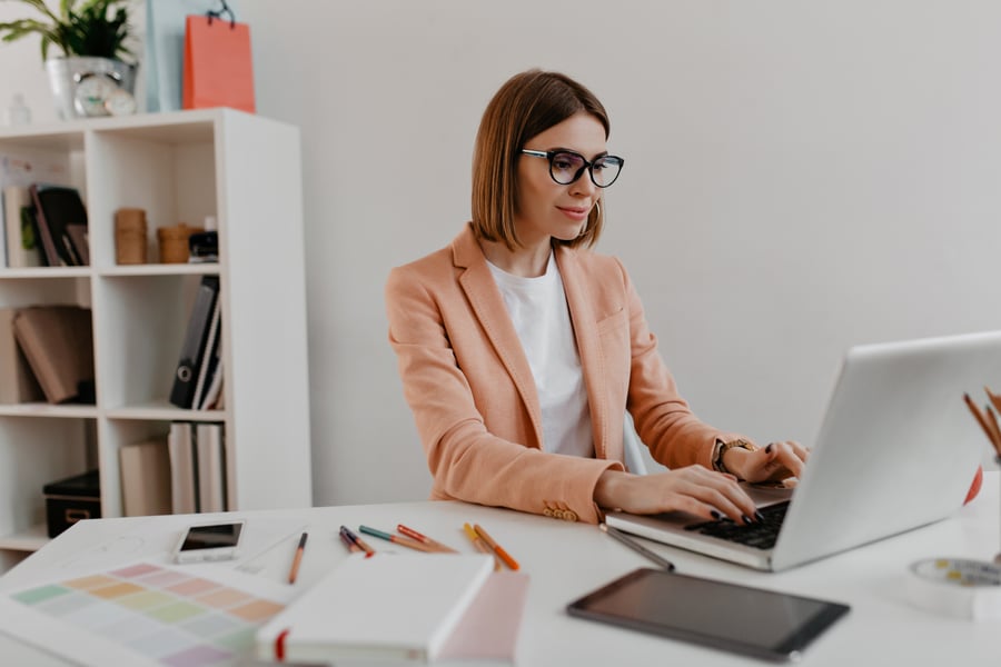 satisfied-business-woman-with-glasses-working-laptop-portrait-young-woman-stylish-outfit-office-furniture